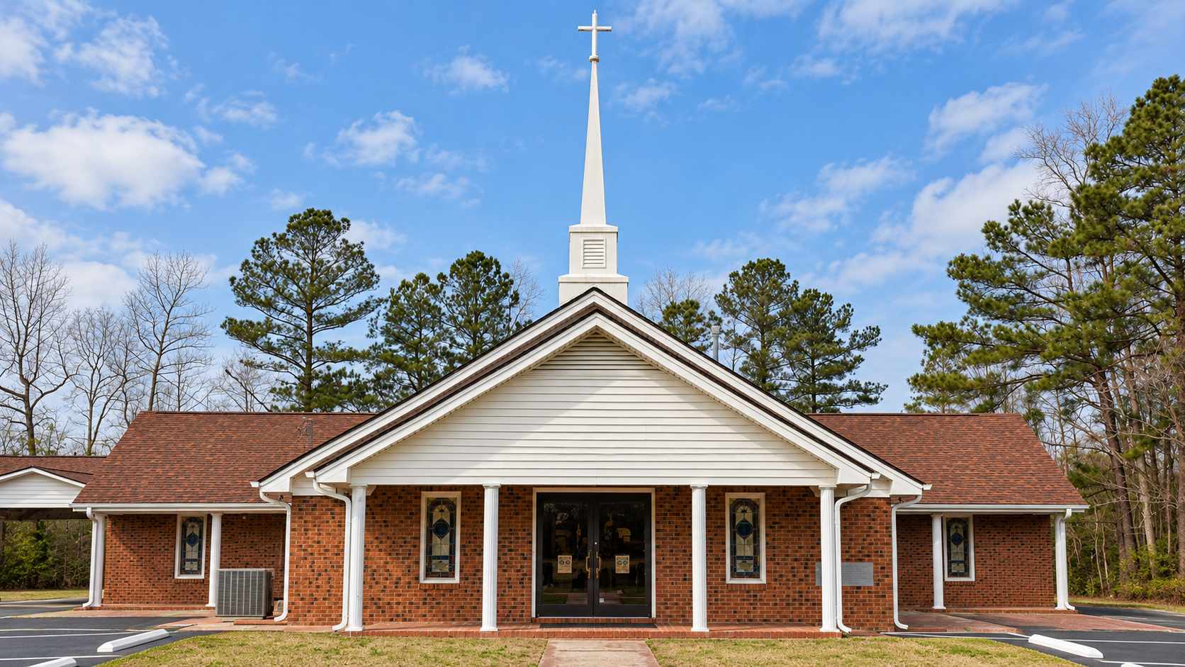 Exterior of Crystal Spring Missionary Baptist Church with its cross, steeple, four-column portico and walkway